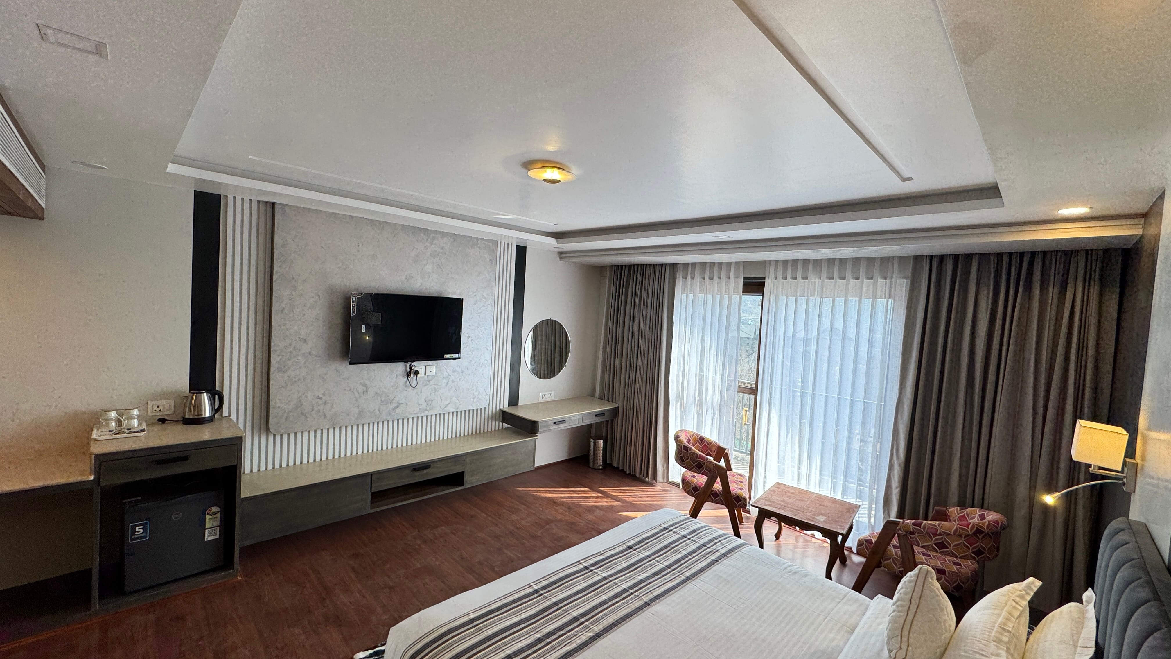 Room interior with TV wall unit and balcony window letting in natural light