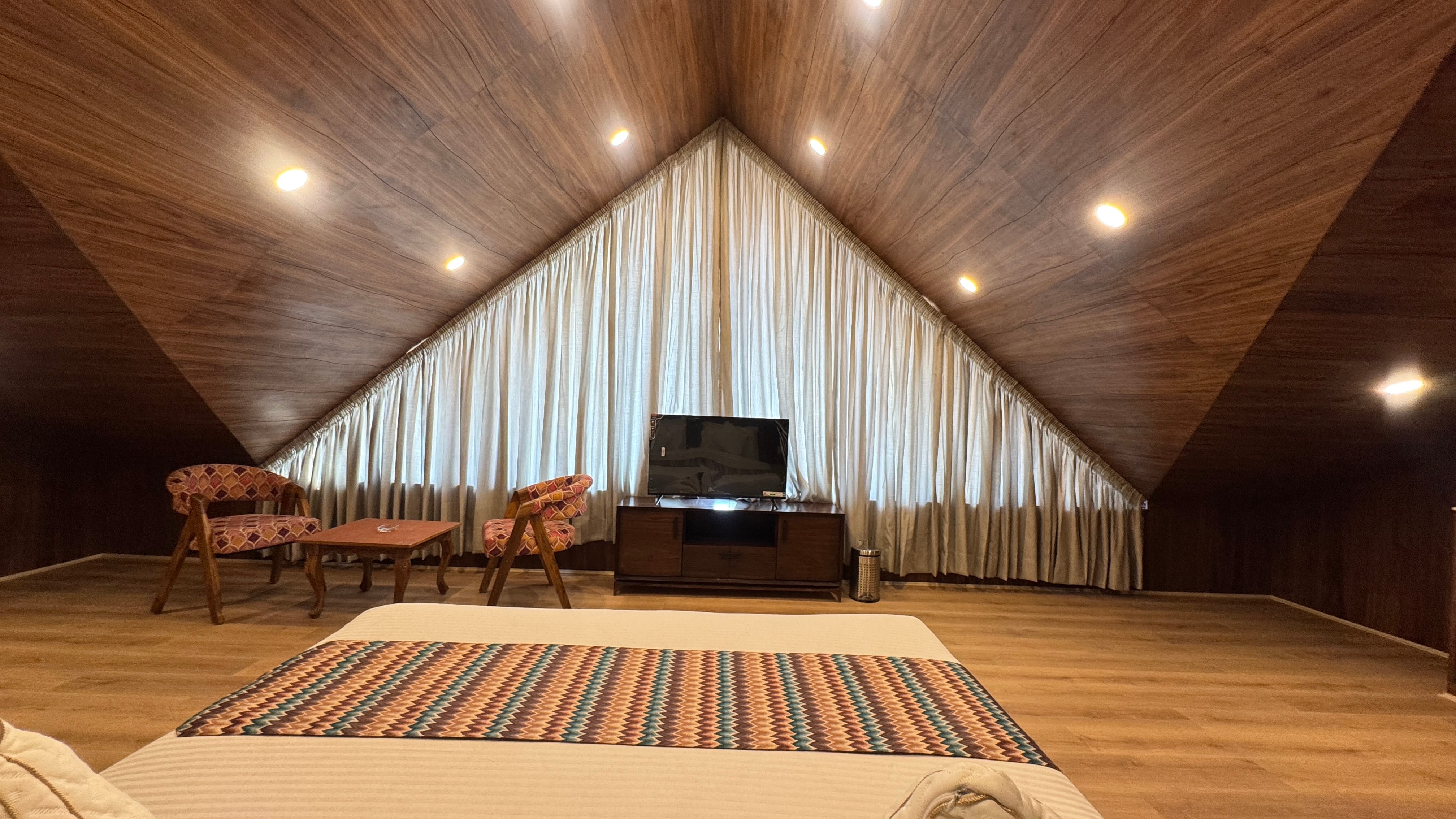 Attic suite with distinctive V-shaped wooden ceiling and cozy atmosphere