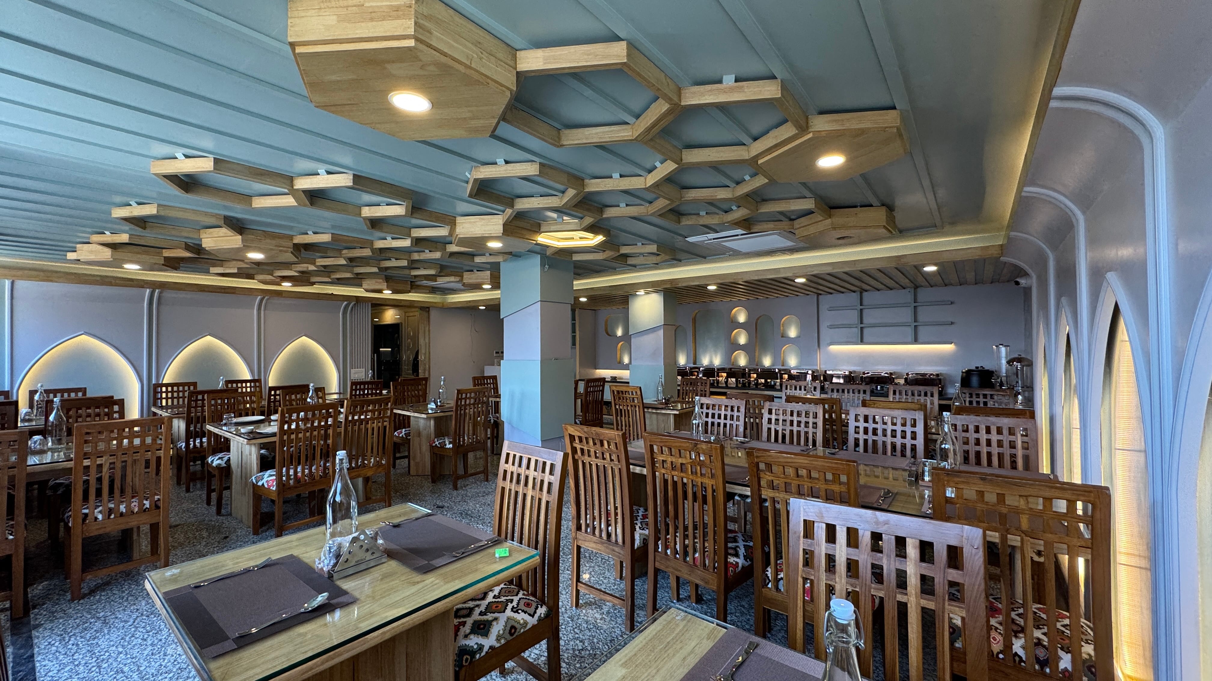 Wide panoramic view of restaurant with hexagonal ceiling and Kashmiri arches